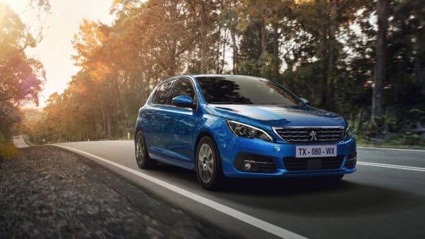 A blue Peugeot 308 is driving along a winding road surrounded by autumn trees in the forest, 4K Desktop Wallpaper