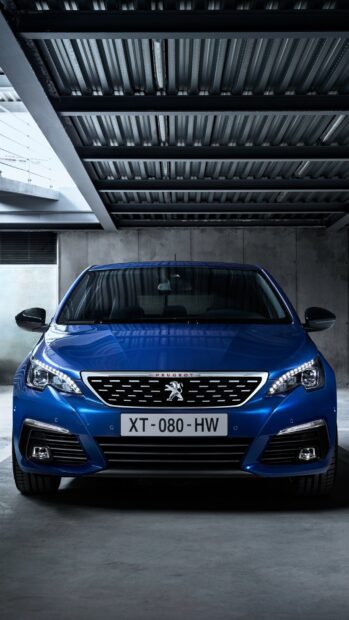 A blue Peugeot 308 is parked inside a modern concrete and metal parking garage, 2K Phone Wallpaper