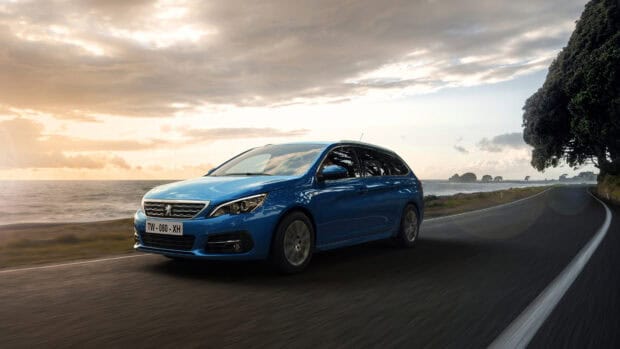 A blue Peugeot 308 is driving along a coastal road during sunset with cloudy sky, 4K Desktop Wallpaper
