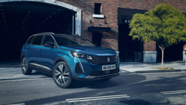 A blue Peugeot 5008 is driving on a street near a brick building and a tree, 4K Desktop Wallpaper