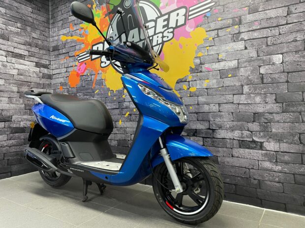A blue Peugeot Kisbee scooter parked indoors with a vibrant paint splash background, HD Desktop Wallpaper