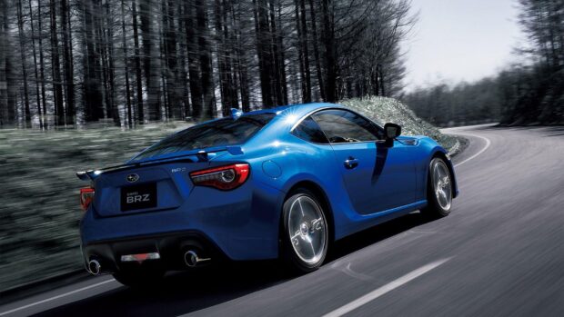 A blue Subaru BRZ is driving on a winding road surrounded by blurred trees, HD Desktop Wallpaper