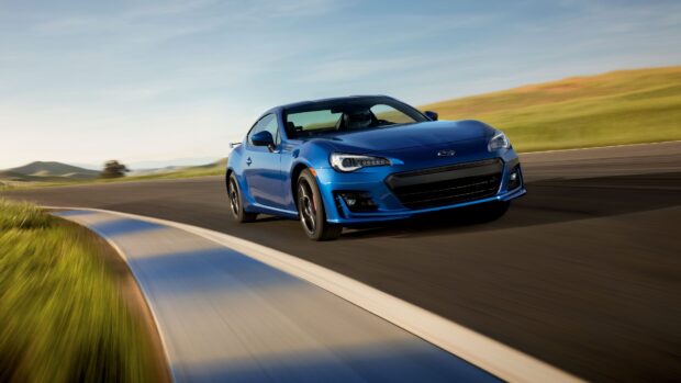 A blue Subaru Brz is driving fast around a curved racetrack in clear weather, 4K Desktop Wallpaper
