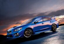 A blue Subaru Wrx is parked on wet pavement under a colorful sunset sky, HD Desktop Wallpaper