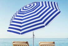 Two lounge chairs under a blue and white beach umbrella by the sea, HD Desktop Wallpaper