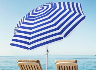 Two lounge chairs under a blue and white beach umbrella by the sea, HD Desktop Wallpaper