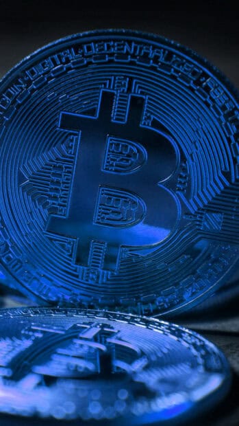 A detailed close up of digital bitcoin coins glowing in blue light, HD Phone Wallpaper