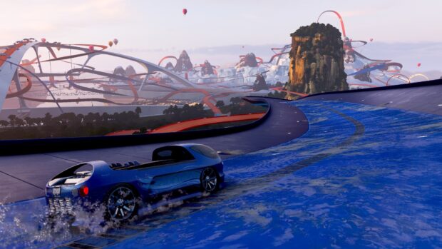 A blue Hot Wheels car races on a wet curved track with mountains and loops in the background, HD Desktop Wallpaper