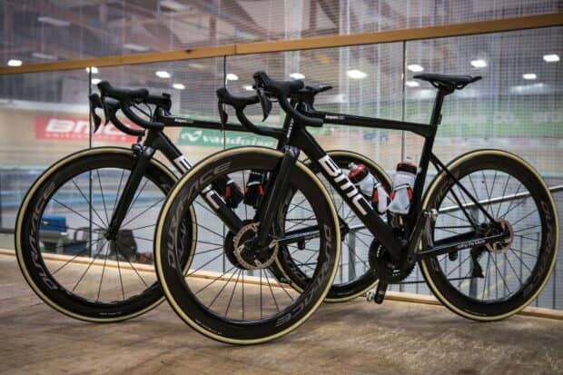 Two Bmc bikes are placed side by side in an indoor cycling arena, HD Desktop Wallpaper