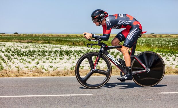 A cyclist rides a Bmc bike on a country road during a race, HD Desktop Wallpaper