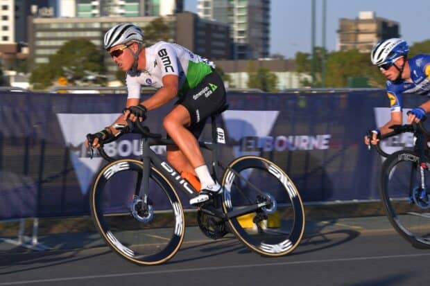 A Bmc Bikes rider is racing on a city street during a competitive cycling event, HD Desktop Wallpaper