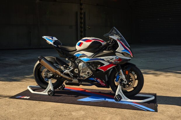 A BMW M 1000 RR motorcycle standing on a mat in a garage setting, HD Desktop Wallpaper