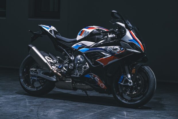 A BMW M 1000 Rr is parked in a dark room highlighting its unique design, HD Desktop Wallpaper