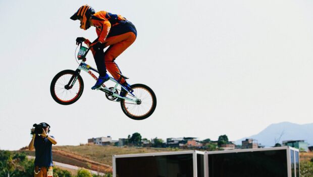 A BMX sports rider is captured mid air during a stunt in an outdoor event, HD Desktop Wallpaper