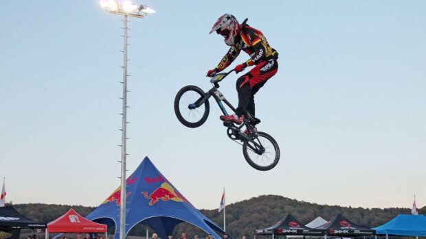 A BMX sports rider is captured mid air during a competition, HD Desktop Wallpaper