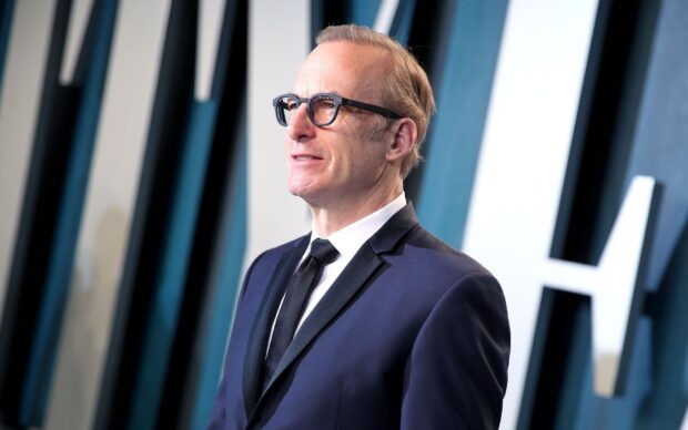 Bob Odenkirk is wearing glasses and smiling slightly in a formal setting, HD Desktop Wallpaper