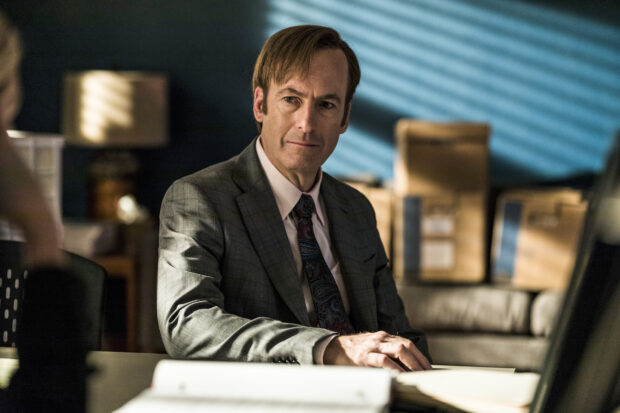 Bob Odenkirk is sitting in a suit with a focused expression during a discussion, HD Desktop Wallpaper
