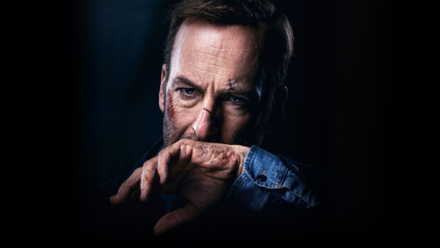 Bob Odenkirk shows a serious expression with facial scars and a hand partially covering his mouth, HD Desktop Wallpaper