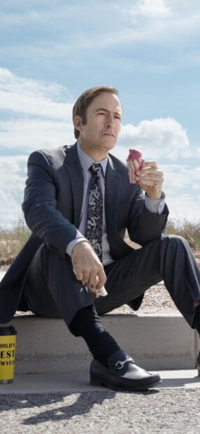 Bob Odenkirk is sitting outdoors eating ice cream while dressed in a suit, HD Mobile Wallpaper