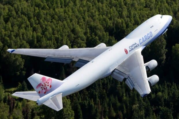 A Boeing 747 cargo plane flying over a forested area during the day, HD Desktop Wallpaper