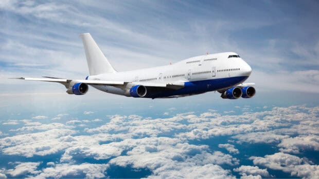 A Boeing 747 is flying high above the clouds with a blue sky in the background, HD Desktop Wallpaper