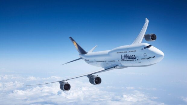 A Boeing 747 is flying above the clouds with a clear blue sky in the background, HD Desktop Wallpaper