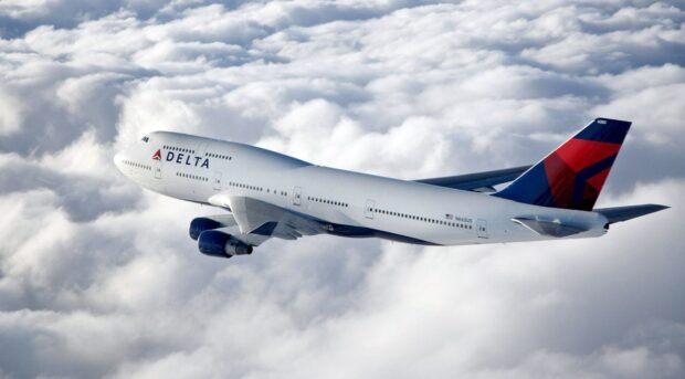 A Boeing 747 in Delta livery flying above the clouds during daytime, HD Desktop Wallpaper