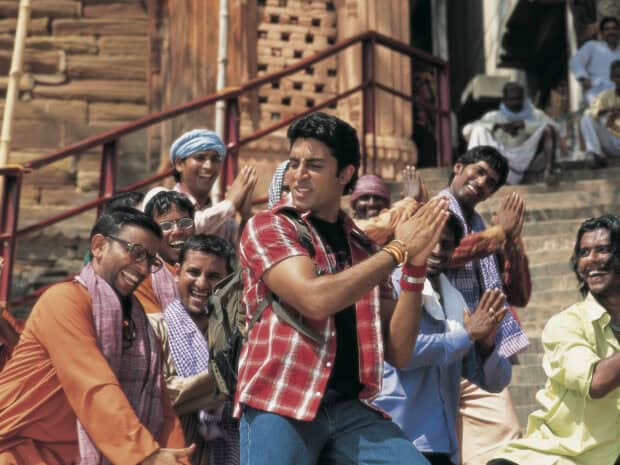 A group of men in traditional attire enjoying a Bollywood moment with joyful expressions on the steps, HD Desktop Wallpaper