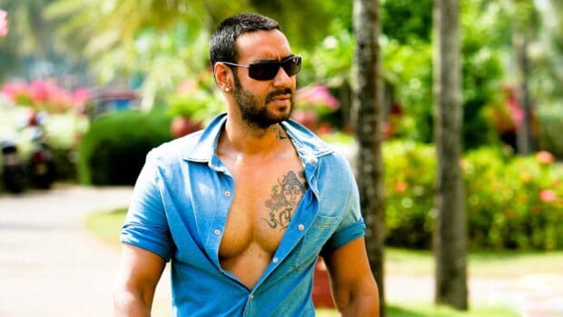 A Bollywood star wearing sunglasses walks outdoors with an open denim shirt revealing a tattoo, HD Desktop Wallpaper