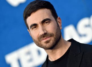 Brett Goldstein is smiling in a close up portrait with a blue background, HD Desktop Wallpaper