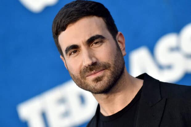 Brett Goldstein is smiling in a close up portrait with a blue background, HD Desktop Wallpaper