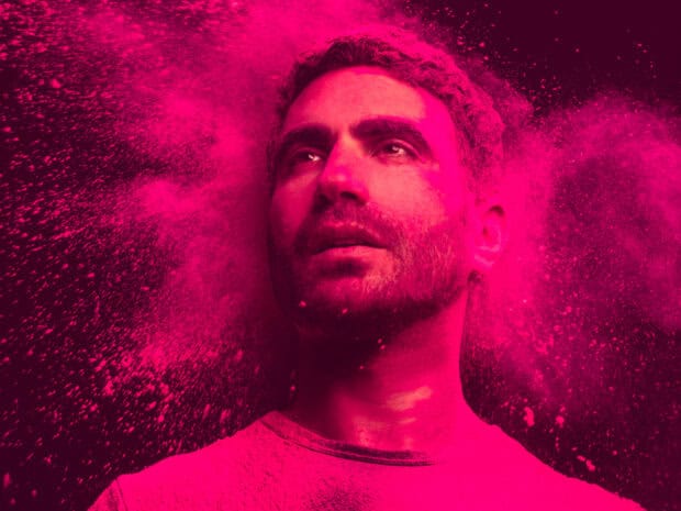 Brett Goldstein covered in bright pink powder looking upward in intense lighting, HD Desktop Wallpaper