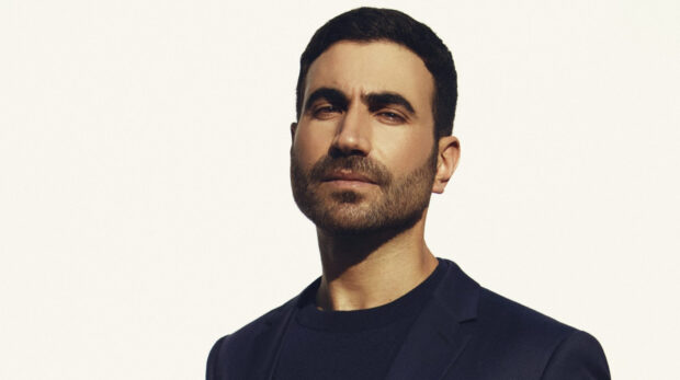 Brett Goldstein stands confidently with a neutral expression, HD Desktop Wallpaper
