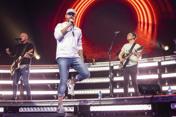 Brett Young performs on stage with band members and bright lights, HD Desktop Wallpaper