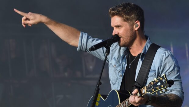 Brett Young is singing and playing guitar during a concert, 2K Desktop Wallpaper
