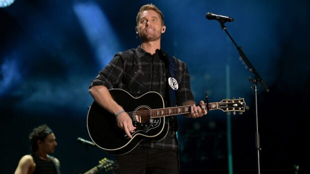 Brett Young performing live on stage playing guitar during a concert, HD Desktop Wallpaper