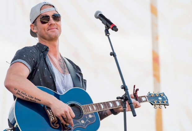 Brett Young wallpapers shows him playing guitar during a concert, 2K Desktop Wallpaper