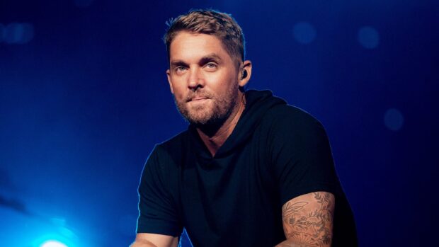 Brett Young is captured during a live performance with a dark blue background, HD Desktop Wallpaper