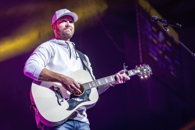 Brett Young is performing live while playing an acoustic guitar on stage, HD Desktop Wallpaper