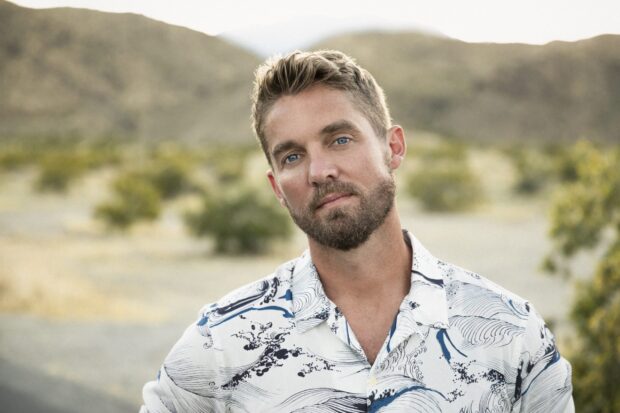Brett Young is standing in a desert setting with mountains in the background, 2K Desktop Wallpaper