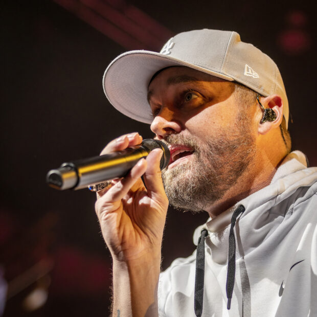 Brett Young Wallpapers shows the singer performing on stage with a microphone, HD Mobile Wallpaper