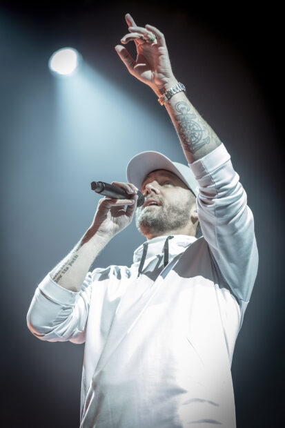 Brett Young singing on stage wearing a white hoodie and cap, HD Phone Wallpaper