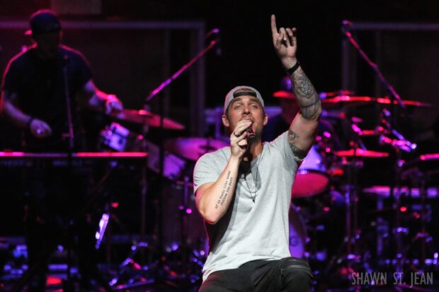 Brett Young is performing passionately with a raised hand on stage, HD Desktop Wallpaper