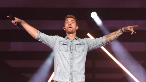 Brett Young is performing on stage with lights in the background, HD Desktop Wallpaper