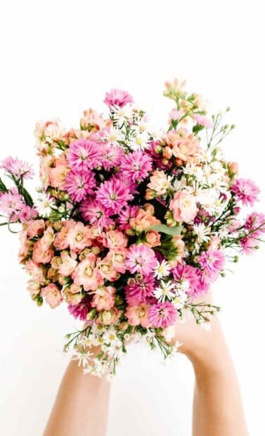 A vibrant bouquet featuring pink and peach flowers held by hands, HD Mobile Wallpaper