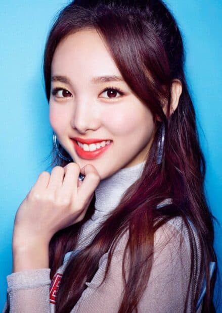 A close up of Nayeon smiling with purple hair and silver earrings on a blue background, HD Mobile Wallpaper
