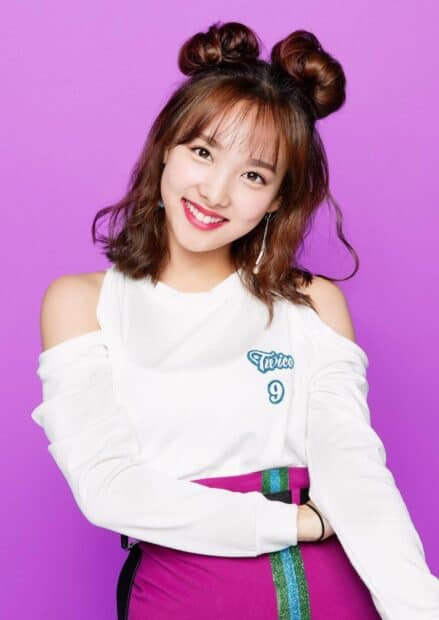 A young woman with playful hairstyle smiles brightly against a purple background featuring Nayeon wallpapers, HD Mobile Wallpaper