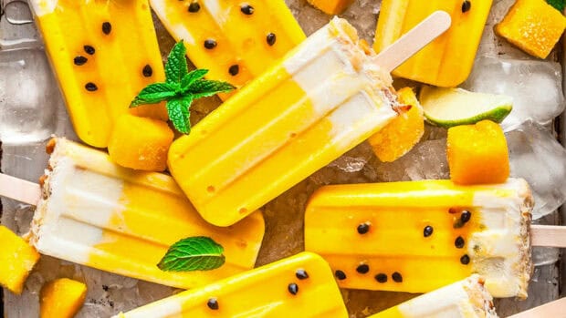 Yellow popsicles with seeds and mint lie on ice cubes, HD Desktop Wallpaper