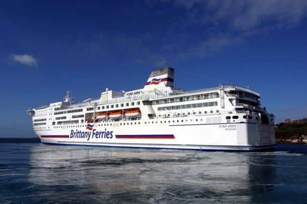 A large Brittany Ferries vessel sails smoothly near the coast under clear skies, HD Desktop Wallpaper