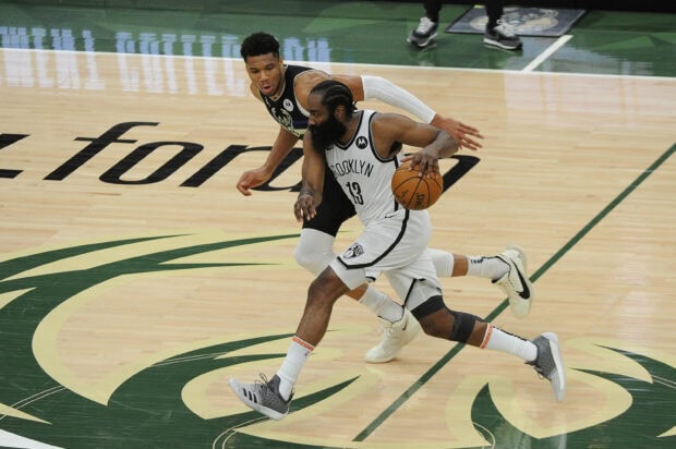 A Brooklyn Nets player drives past a defender on the basketball court during an intense game, 2K Desktop Wallpaper
